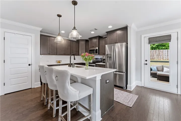 Prepare meals and entertain guests in this luminous kitchen, boasting a spacious island and gleaming stainless steel appliances.