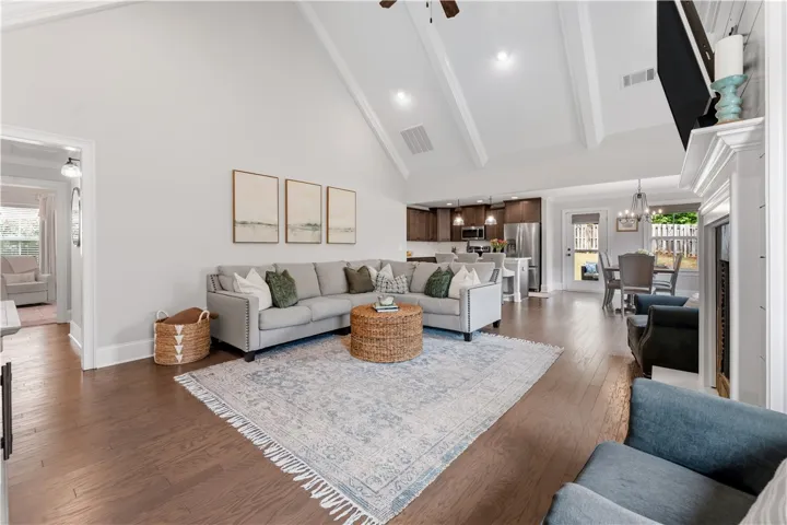 Lofty vaulted ceilings elevate this open-concept living space with gleaming hardwood floors throughout.