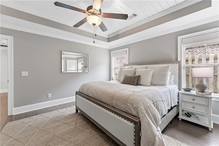 Hardwood floors and a stylish ceiling fan elevate this tranquil sleeping space.