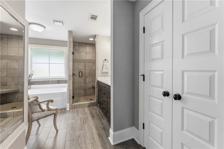 Indulge in this bathroom featuring an inviting soaking tub and a sleek, modern walk-in shower.
