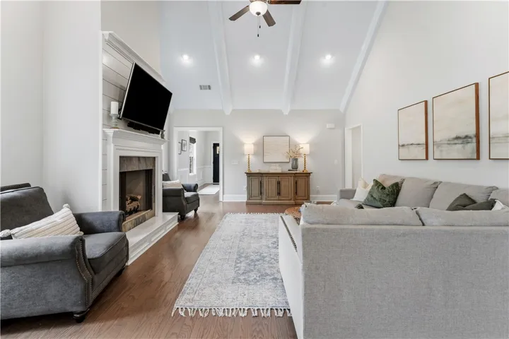 A refined living space showcases a prominent fireplace and a soaring beamed ceiling.