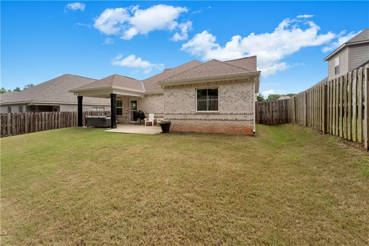 A generous backyard features a covered patio and privacy fencing, perfect for outdoor enjoyment.