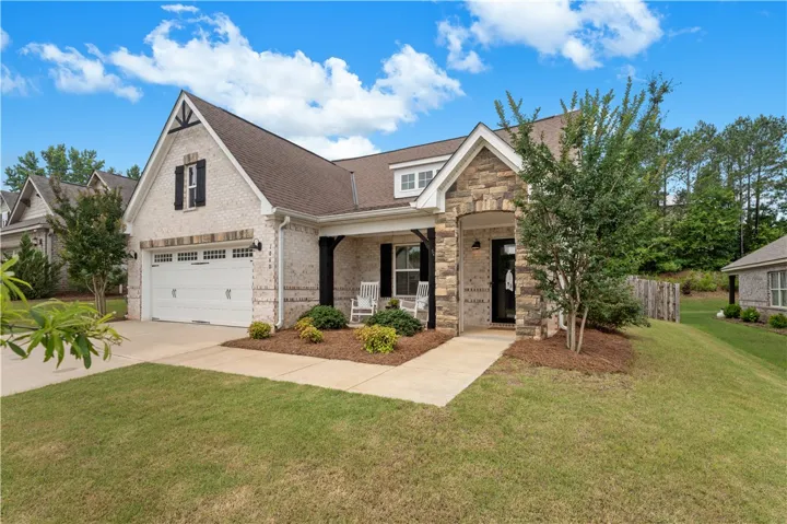 A welcoming stone and brick facade creates inviting curb appeal for this charming residence.