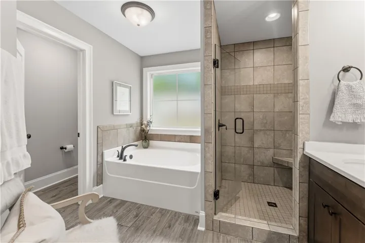 Indulge in a tranquil bathing experience with this generously sized tub and separate tiled shower.