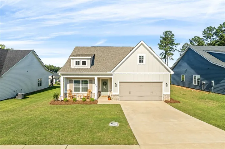 A charming single-story home with an inviting front porch and attached garage.