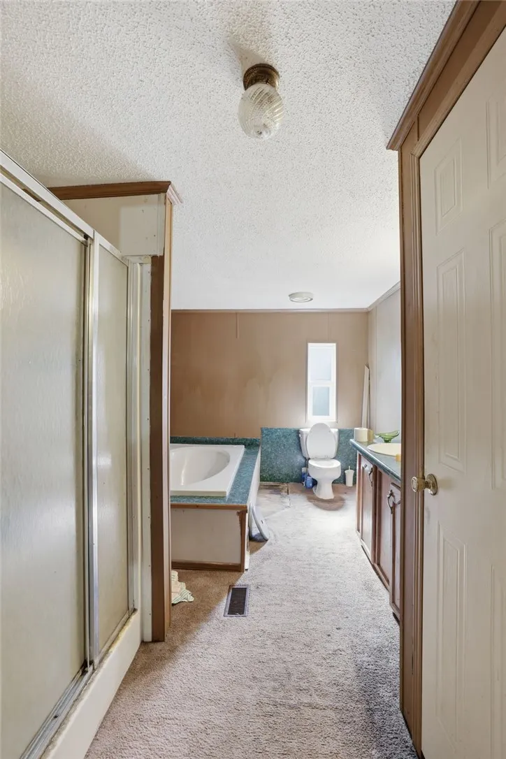 A functional bathroom layout offers a shower, bathtub, and vanity for daily routines.