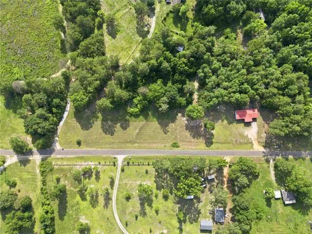 An aerial perspective reveals a vast, verdant lot offering ample space and serene surroundings.