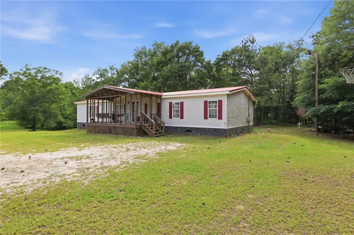 A welcoming front facade with a screened porch and ample green space awaits.