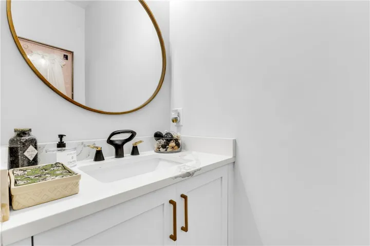 A sleek vanity with a striking black faucet and modern gold hardware anchors this well-appointed bathroom.