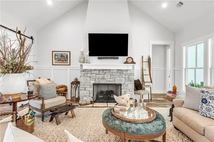 A striking stone fireplace anchors this living space, offering warmth and a dramatic focal point.