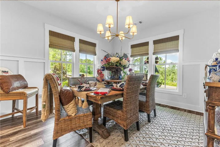 Natural light floods this dining area through abundant windows, highlighting the stylish wainscoting.