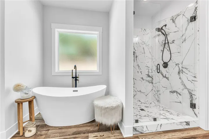 Luxurious spa bath retreat features a contemporary freestanding tub and a spacious walk-in shower with marble-look tile.