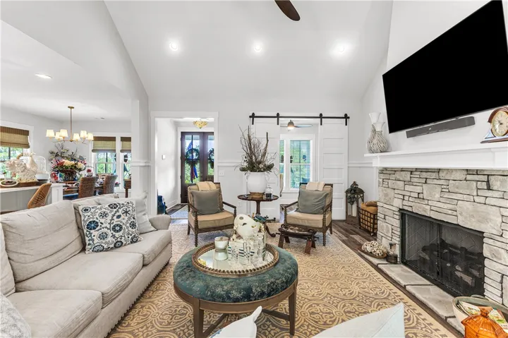 A stone-clad fireplace and soaring vaulted ceilings define this inviting living space.