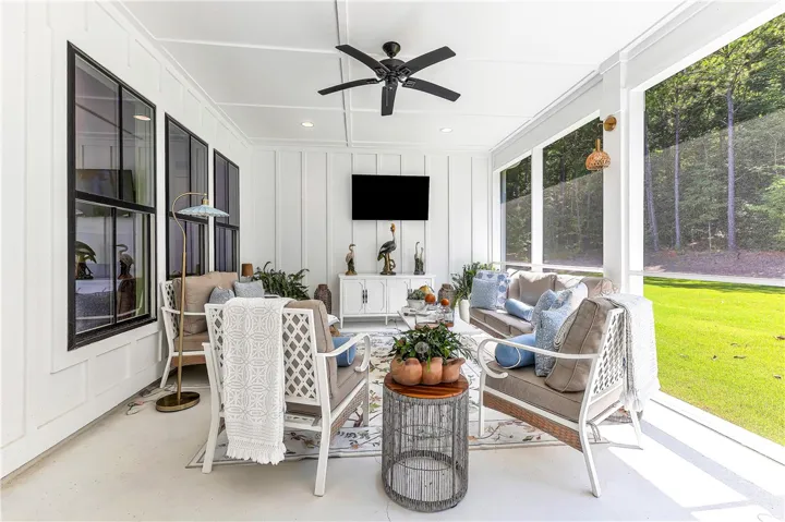 A screened porch with a clean white aesthetic and natural light, perfect for outdoor relaxation.