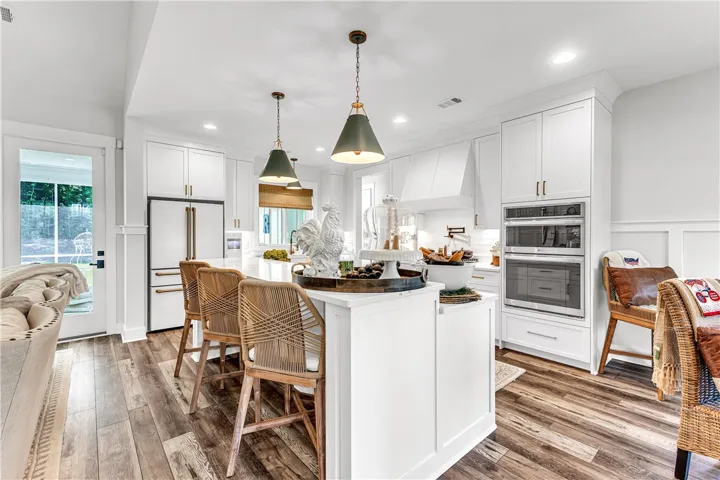 Bright, open-concept kitchen features a spacious island with seating and sleek built-in appliances.