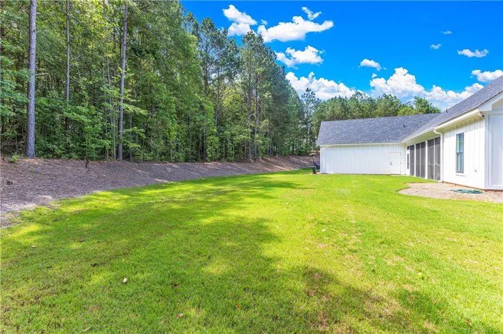 A verdant backyard with mature trees bordering the property and a private screened porch.