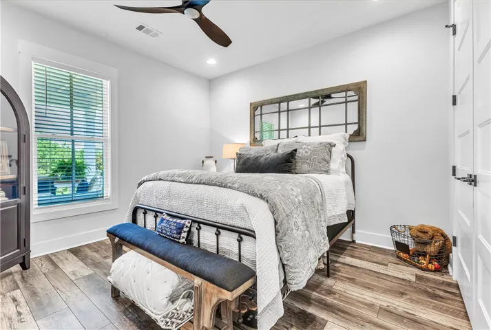A quiet retreat, this bedroom offers wide-plank flooring and ample natural light from its large window.