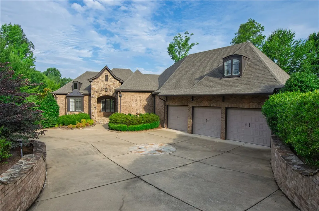 Elegant brick and stone facade welcomes guests with a spacious driveway and attached garages.