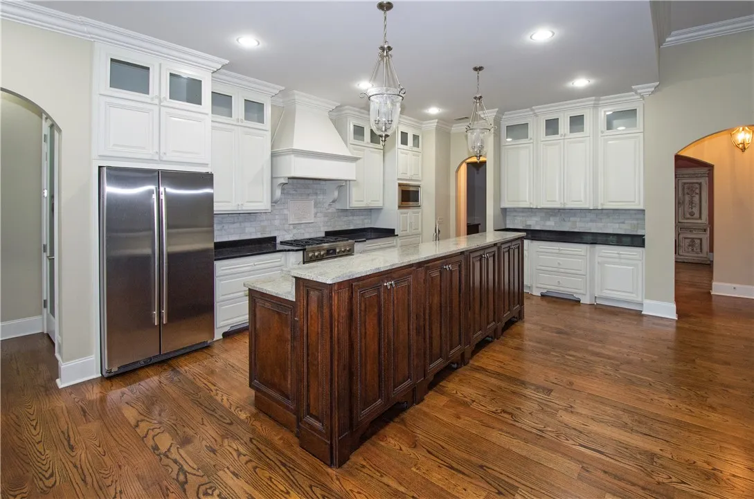 An inviting kitchen with a substantial island and gleaming hardwood floors.