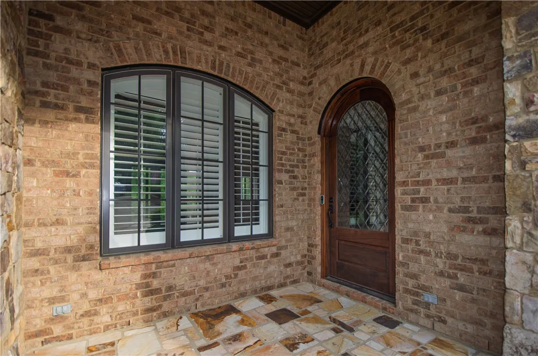 Arched windows and a stately front door enhance this home's inviting brick and stone façade.