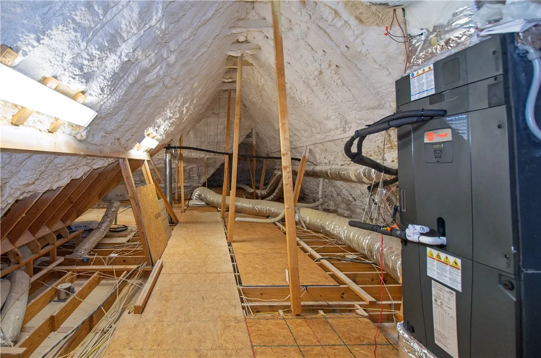 Insulated attic with visible ductwork and mechanical systems, ready for conversion or storage.