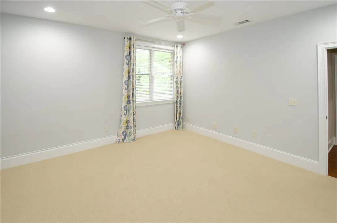 A restful chamber offers recessed lighting and a ceiling fan for optimal comfort.