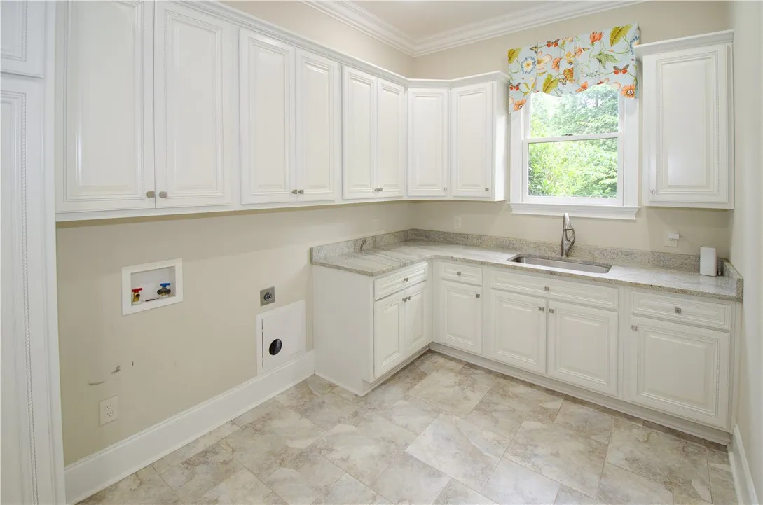 Ample cabinetry and stone countertops elevate this well-appointed utility space.