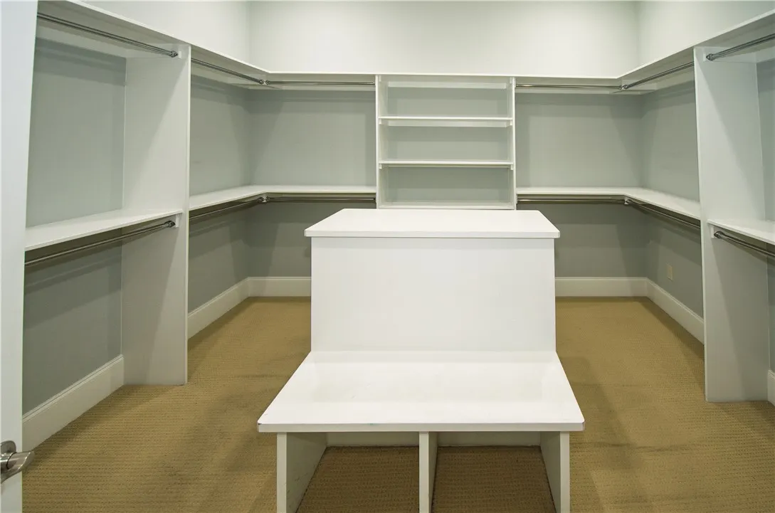 Ample storage solutions abound in this well-organized walk-in closet, featuring extensive shelving and hanging rods.