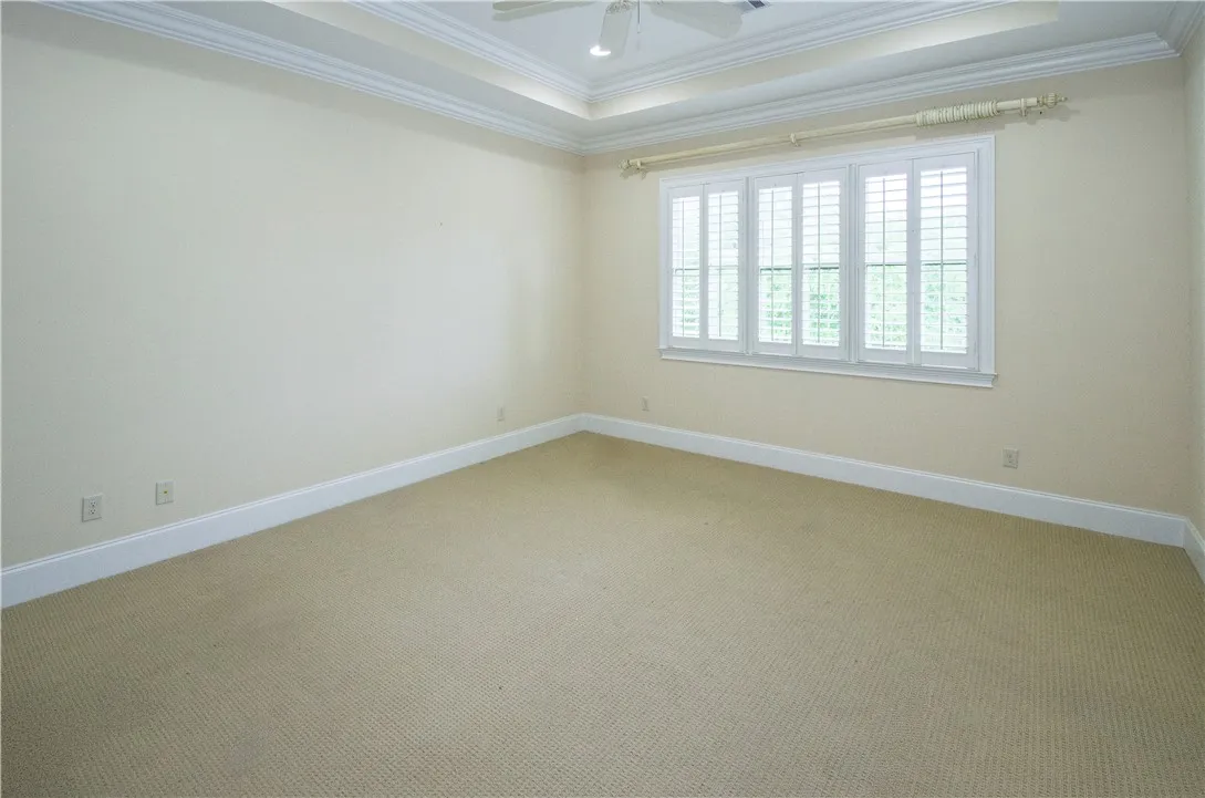 A quiet retreat with plush carpeting and natural light filtering through plantation shutters.