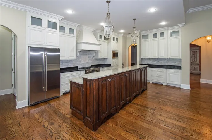 An inviting kitchen with a substantial island and gleaming hardwood floors.