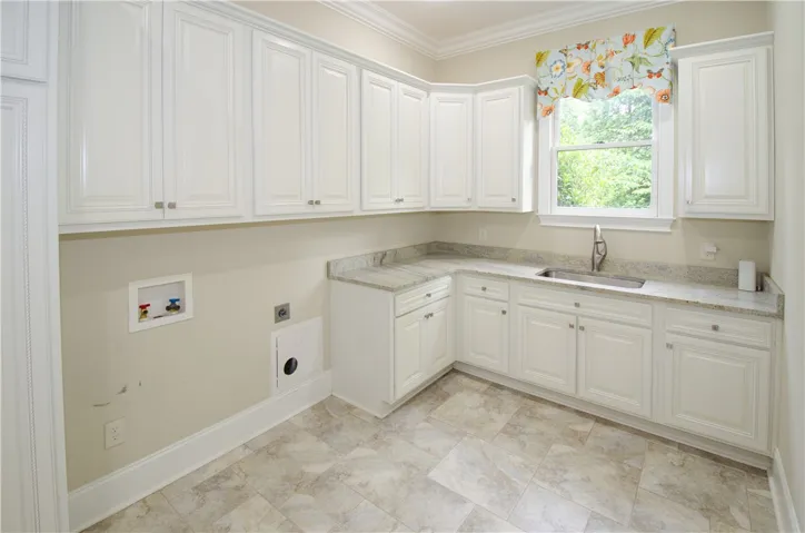 Ample cabinetry and stone countertops elevate this well-appointed utility space.