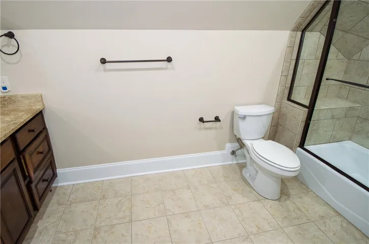A well-appointed bath with tiled flooring and a convenient shower-tub combination.