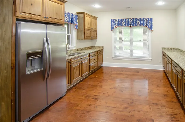 Well-appointed kitchen featuring granite countertops and natural wood cabinetry with ample space for culinary endeavors.