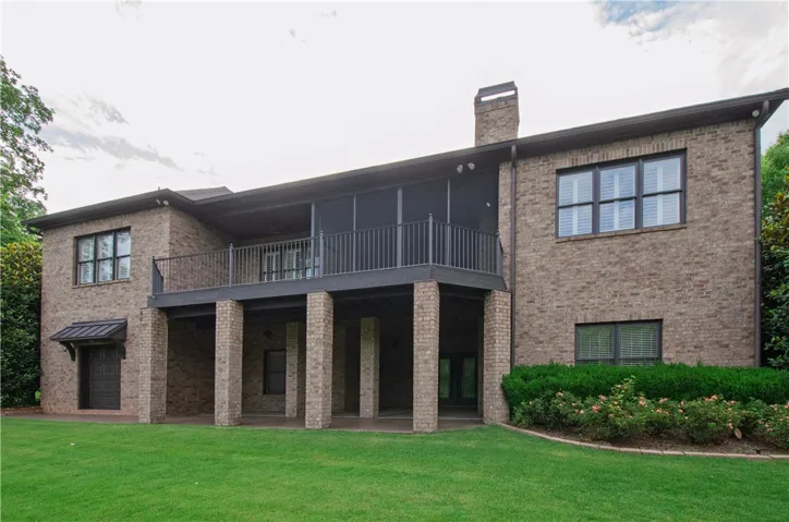 A classic brick exterior offers generous covered patio space and an upper-level balcony, ideal for outdoor enjoyment.