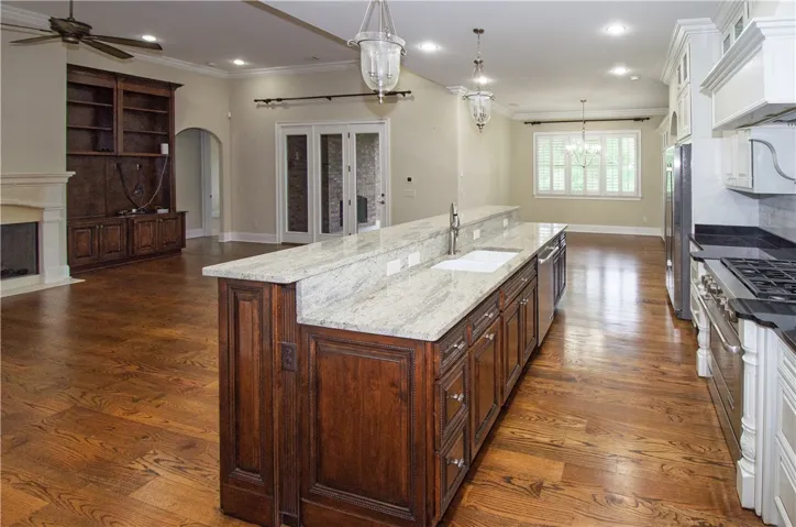 An open concept living space with gleaming hardwood floors connects a gourmet kitchen and inviting living area.