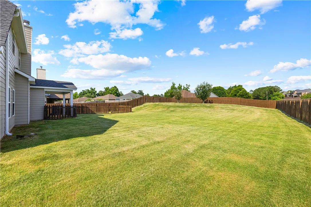 A spacious, fenced backyard offers ample room for outdoor activities.