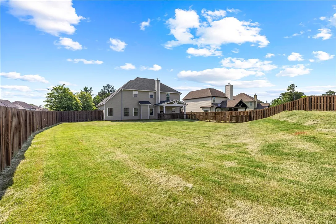 A spacious, fenced backyard offers ample room for outdoor activities and relaxation.