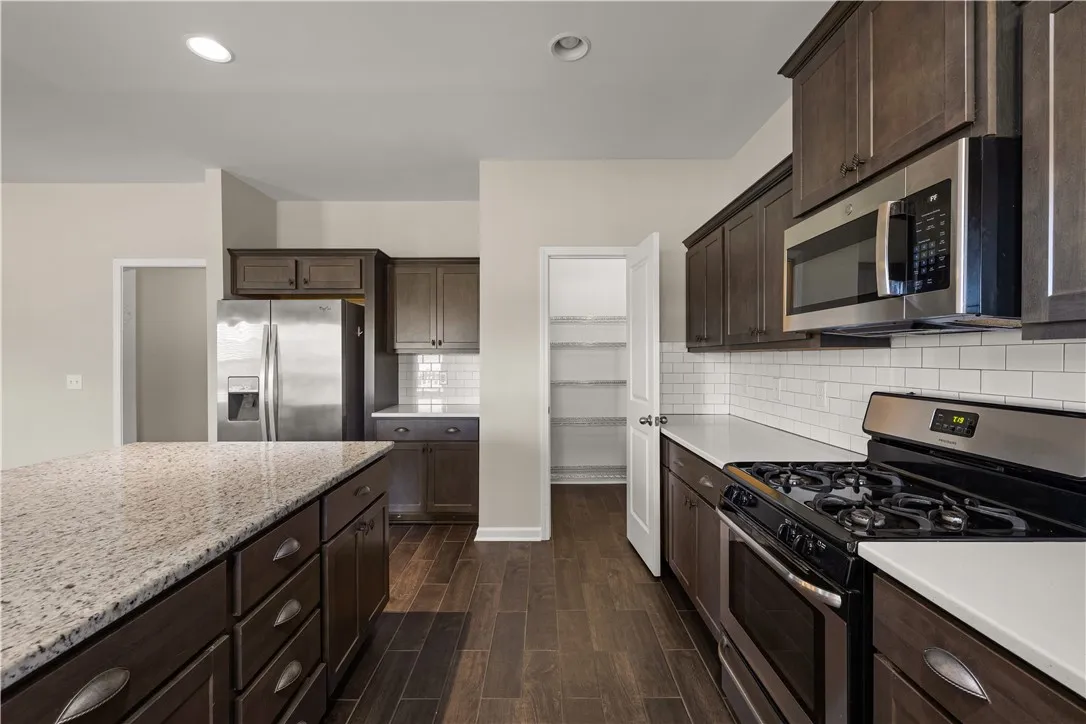 Culinary creations come alive in this kitchen, boasting sleek granite counters and dark wood cabinetry.