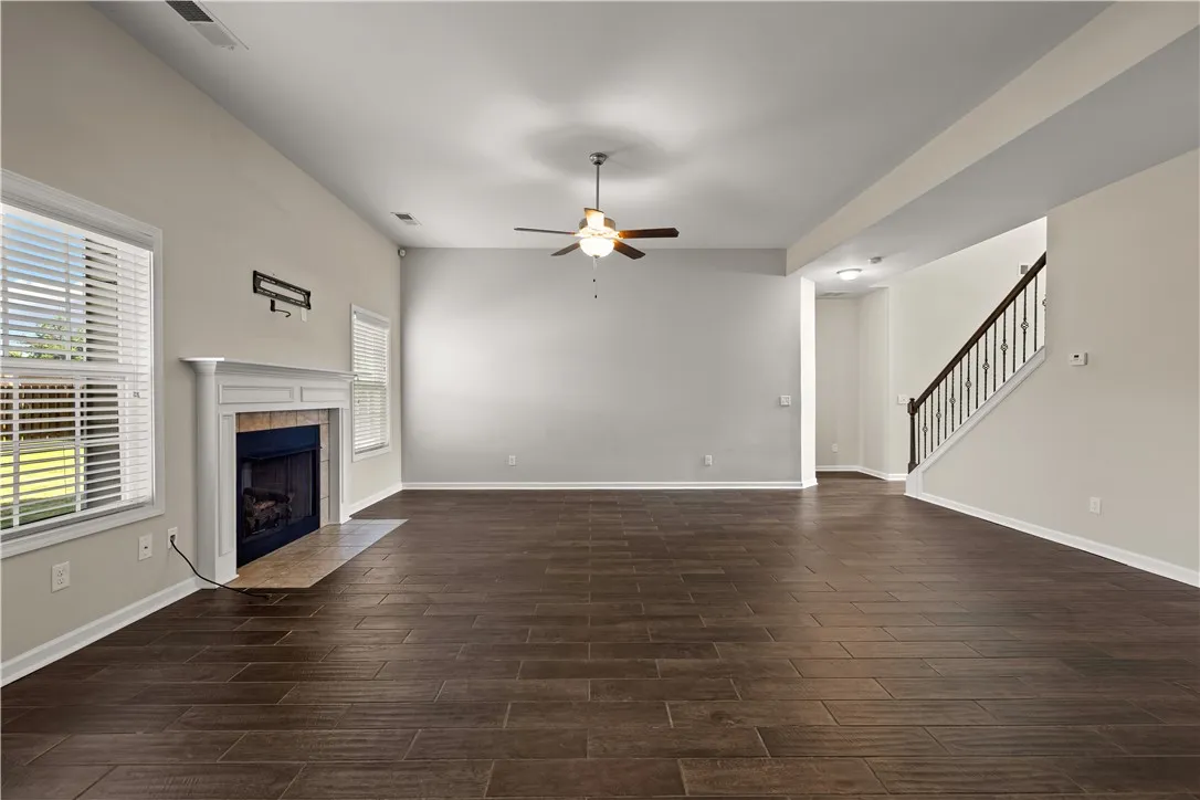 A spacious common area boasts rich, dark tile flooring and a traditional fireplace.