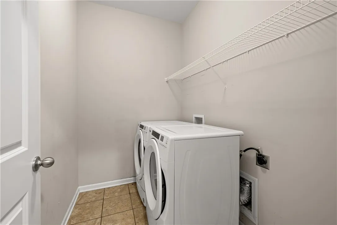 Practical laundry space offers convenience with ample overhead shelving for storage.