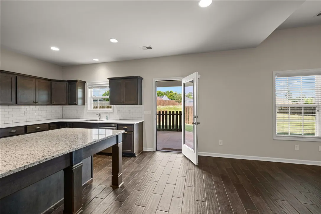 A well-appointed kitchen features rich cabinetry, generous counter space, and convenient outdoor access.
