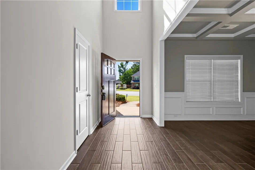 Enter into a soaring foyer with natural light and elegant coffered ceilings in the adjoining space.