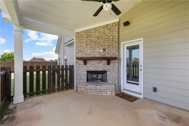 An inviting outdoor patio features a brick fireplace, offering a cozy ambiance for relaxation.