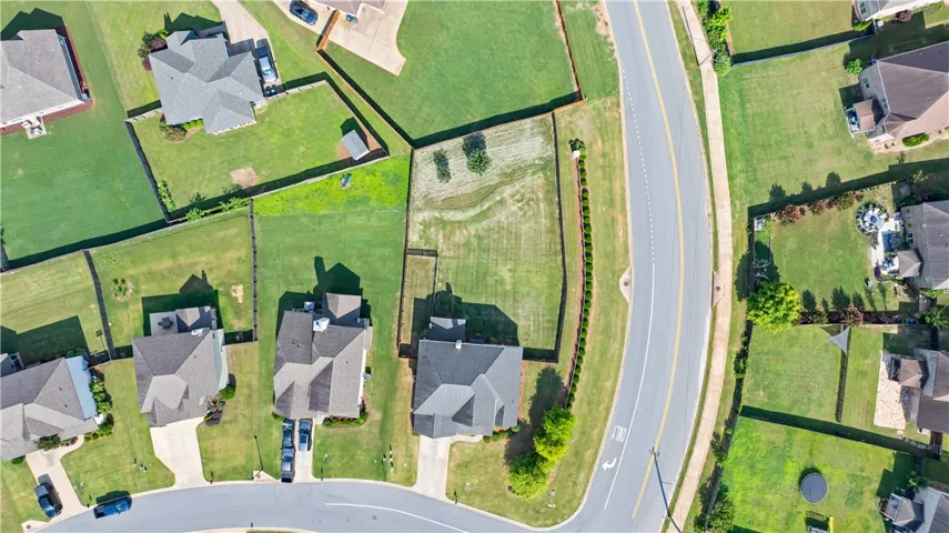An aerial perspective reveals a well-maintained neighborhood with lush green yards and manicured landscaping.