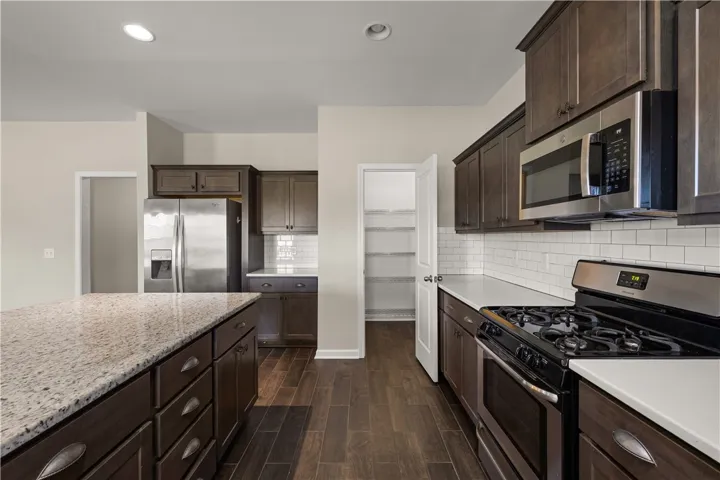 Culinary creations come alive in this kitchen, boasting sleek granite counters and dark wood cabinetry.