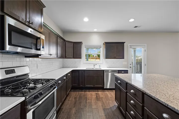 Culinary delights await in this modern kitchen with granite countertops and rich wood cabinetry.
