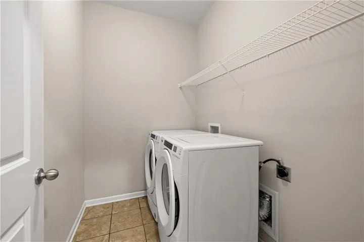 Practical laundry space offers convenience with ample overhead shelving for storage.