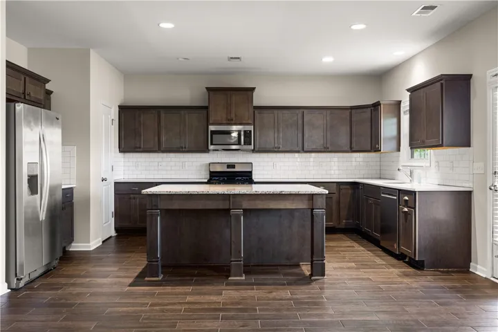 Culinary creations come to life in this spacious kitchen featuring rich cabinetry and a central island.
