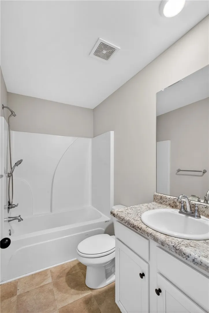 A well-appointed bathroom offers a clean vanity with ample counter space and a classic tub/shower combination.