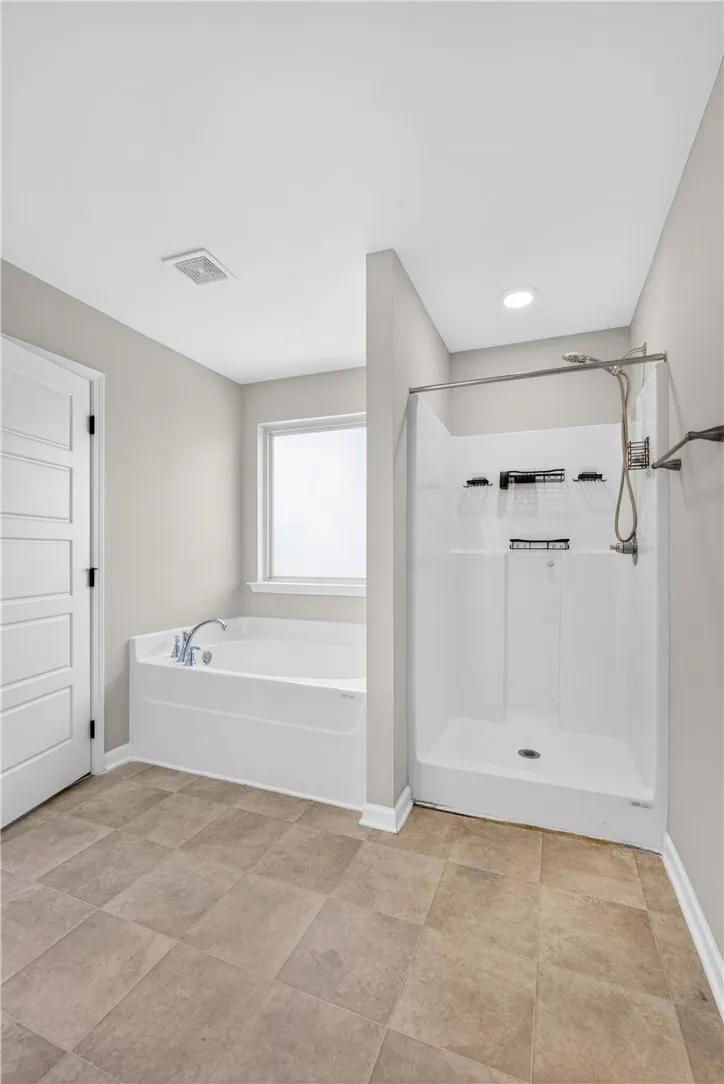 A well-appointed bathroom offers a separate soaking tub and walk-in shower for ultimate comfort.